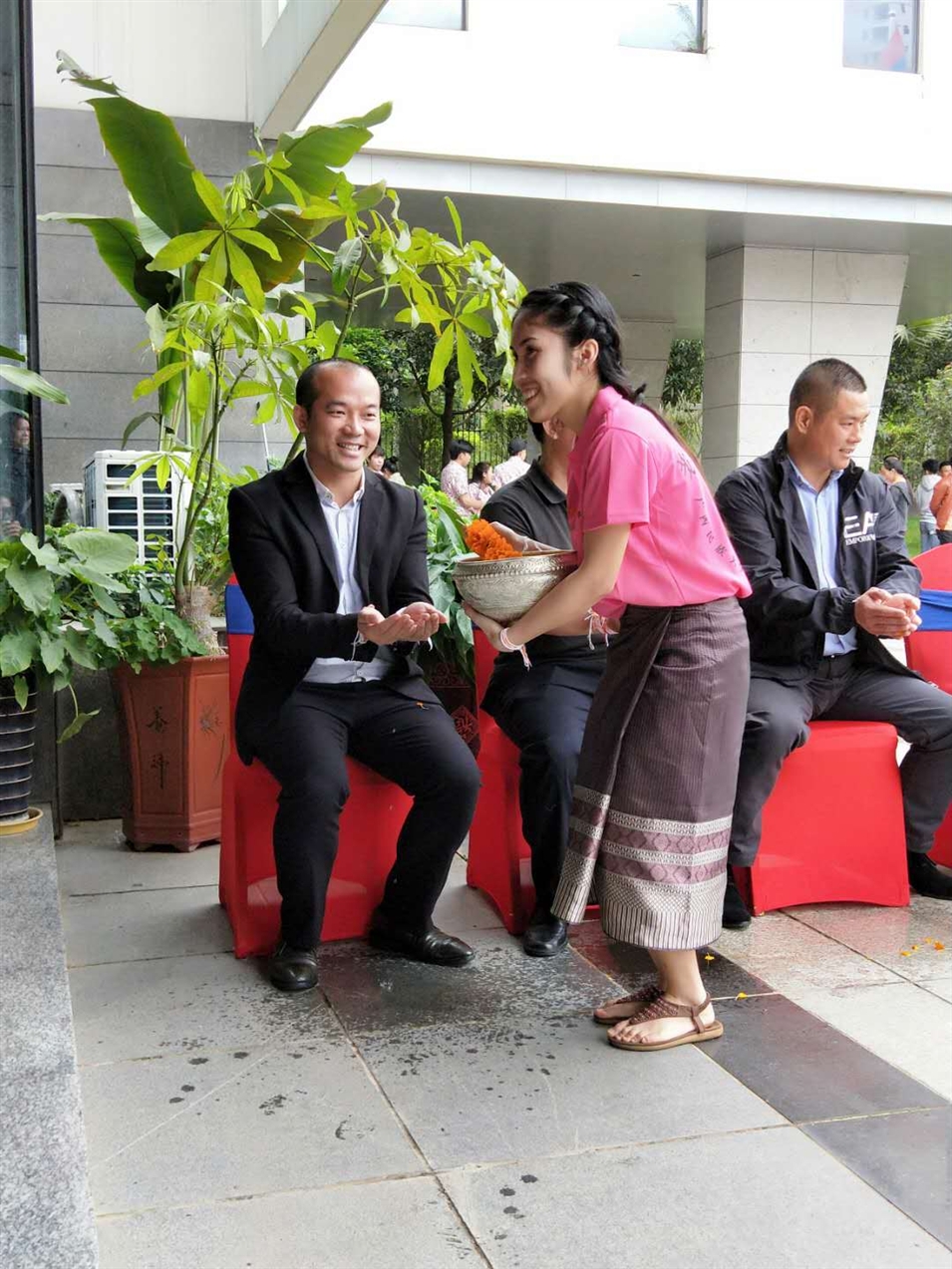 老撾駐廣西留學(xué)生代表將浸有花瓣的香水灑客人的手上，表示對嘉賓的美好祝福（圖一）